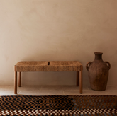 Azul 2‑seater rope‑weave bench styled in a Mediterranean room with clay urn and Moroccan runner.